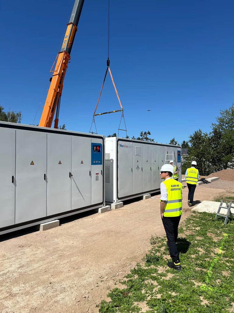 Man standing next to a grid-scale battery unit